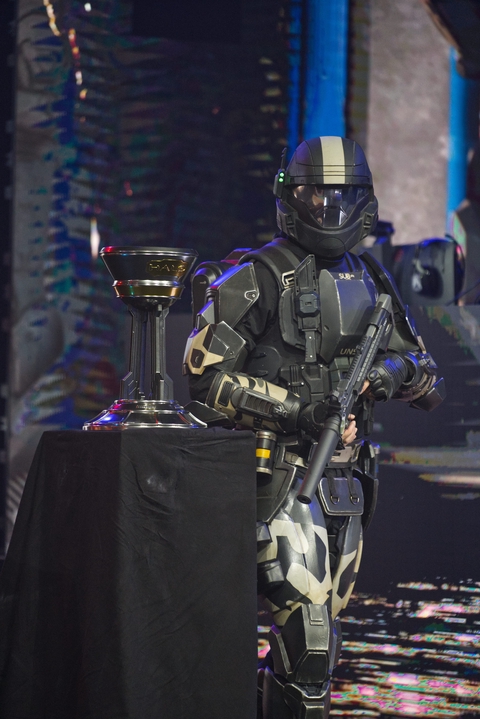 An ODST looking towards the camera, next to the Halo World Championship trophy.